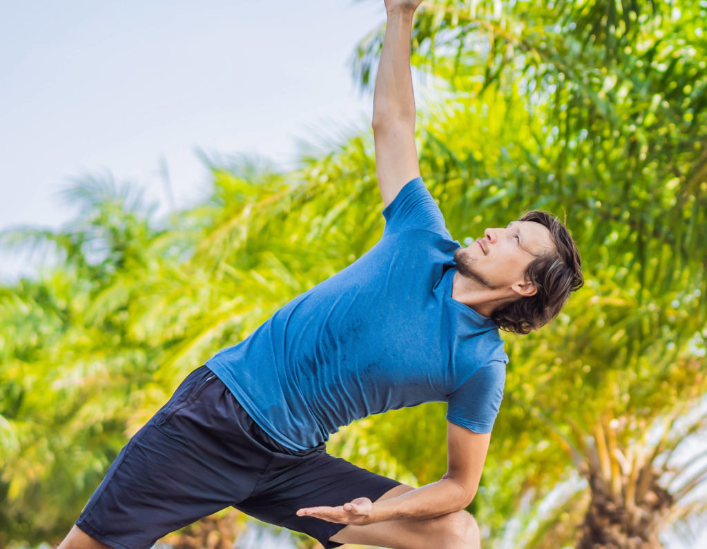 Man doing yoga in a tropical garden of the Bounty Lodge